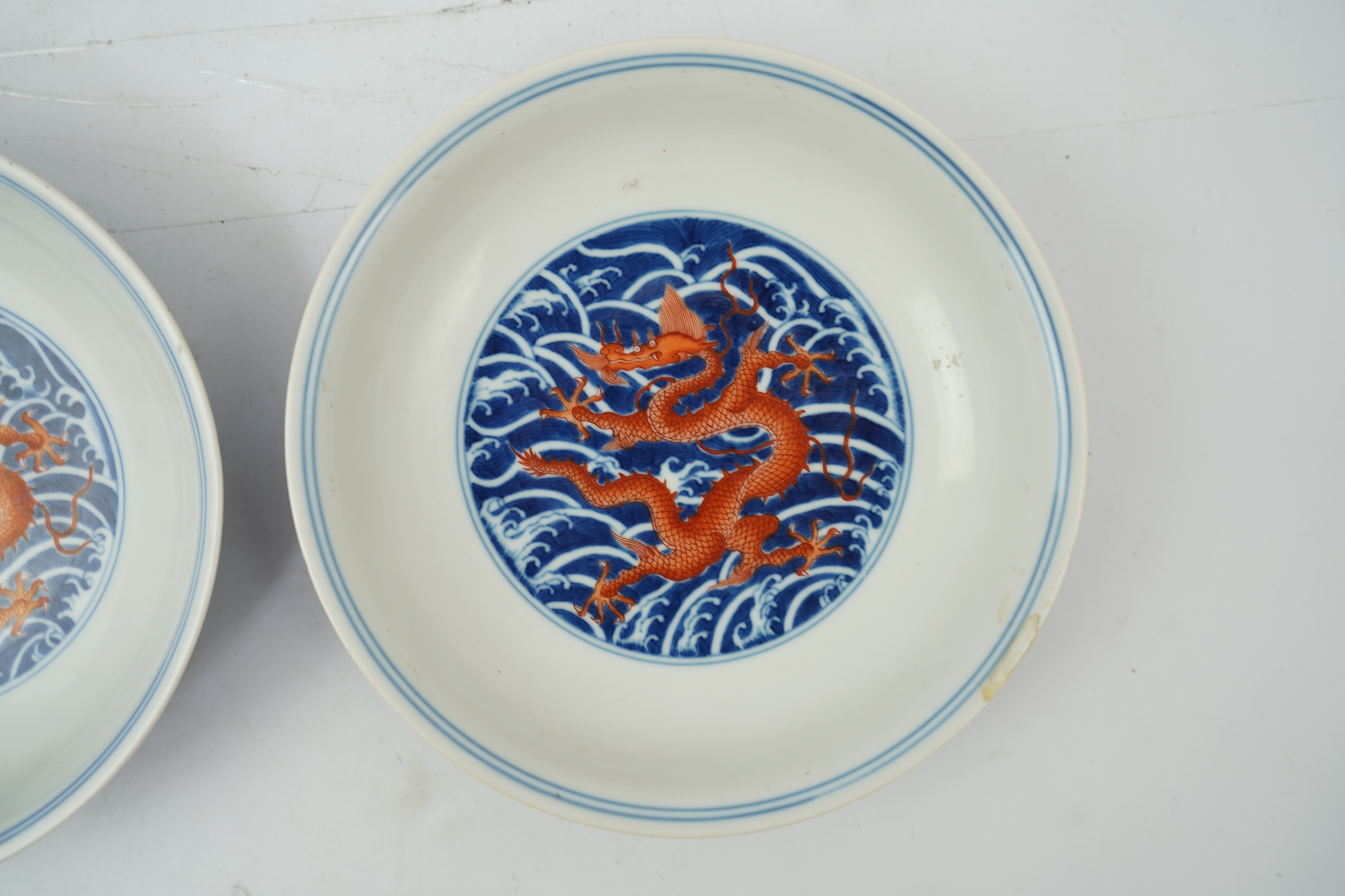 A pair of Chinese iron red and underglaze blue ‘dragon’ dishes, Qianlong seal mark and of the period (1736-95)
